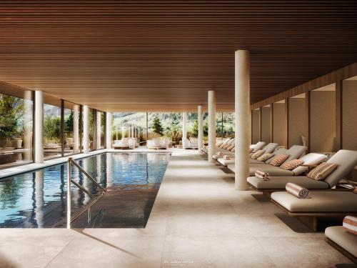 a swimming pool with lounge chairs and a pool house at Hotel Oberforsthof in Sankt Johann im Pongau