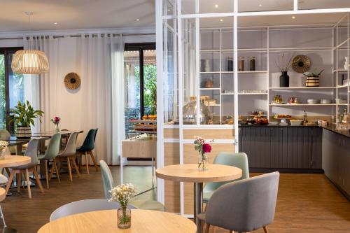 a restaurant with tables and chairs and a counter at Hotel Paris Louis Blanc in Paris