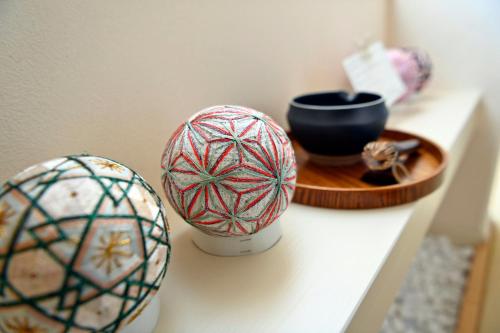 two balls of yarn sitting on a shelf next to a bowl at Maccha House Near Zenkoji Nagano in Nagano