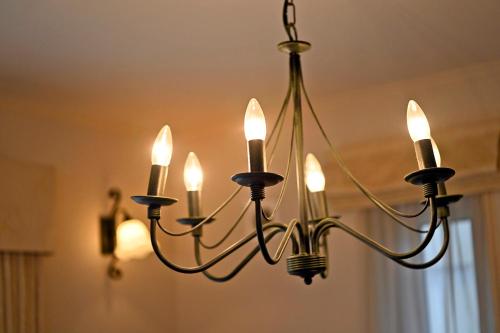 a chandelier with nine lights hanging from a ceiling at Maccha House Near Zenkoji Nagano in Nagano