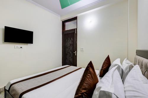 a bedroom with a bed and a tv on a wall at Hotel Sunshine By The Premium Villa in New Delhi