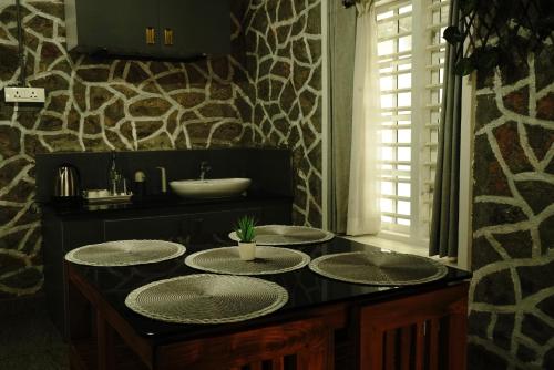 a bathroom with a sink and four plates on a counter at Villa La Vista Homestay in Calicut