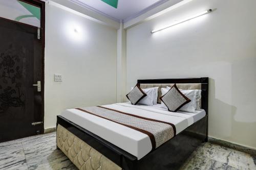 a bedroom with a bed with white sheets and pillows at Hotel Sunshine By The Premium Villa in New Delhi