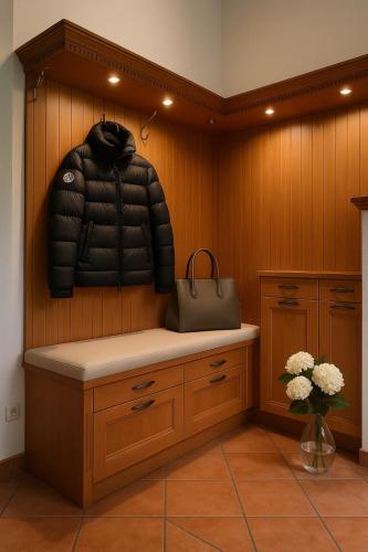a room with a bench with a puffer jacket on the wall at Auhäusl Residence for 6 with private Sauna by Belle-Stay in Reith bei Kitzbühel