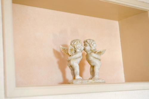 a couple of angel statues sitting on a wall at Maccha House Near Zenkoji Nagano in Nagano