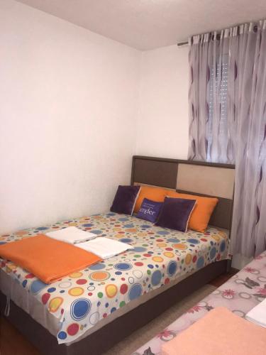 a bedroom with a bed with colorful sheets and pillows at Milun Stan in Sutomore
