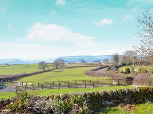 a field of green grass with a fence in the foreground at The Bungalow in Pentrich