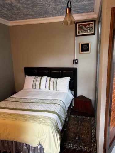 1 dormitorio con cama con sábanas blancas y techo en Garden Studio in Waterkloof Ridge, en Pretoria