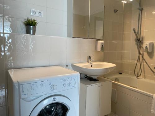 un bagno con lavatrice e lavandino di Corvin Center Suites a Budapest