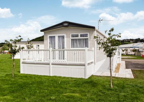 a tiny house with a white fence at Riverside Holiday Village in Uphill