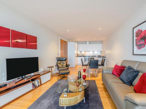 a living room with a couch and a flat screen tv at Apartment 50 in Westward Ho