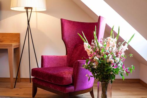 a purple chair and a vase of flowers in a room at Gasthof Zufriedenheit in Naumburg