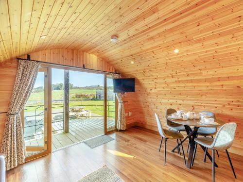a dining room with a table and chairs and a balcony at Primrose - Uk42358 in Saint Harmon