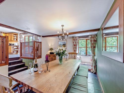 a dining room with a wooden table and some windows at The Old Roundhouse in Hartland