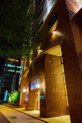 a building with lights on the side of it at night at Hotel Resol Sapporo Nakajima Koen in Sapporo