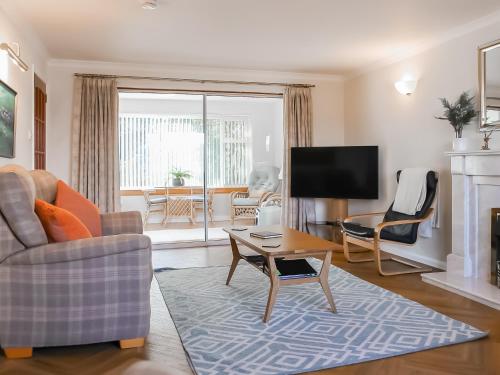a living room with a couch and a tv at Argyle View in Dunblane