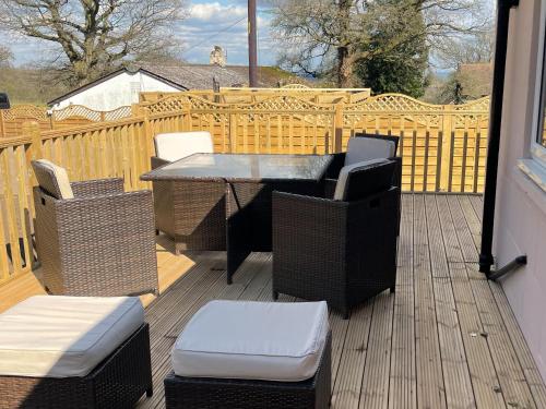 a patio with a table and chairs on a deck at The Old Kitchen -Uk32062 in Burwarton