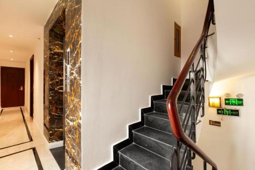 a staircase in a house with a stone wall at Grand Mays Inn Hotel & Spa in Ho Chi Minh City