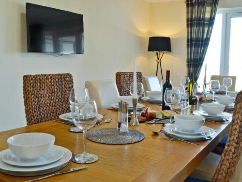 a wooden table with glasses and plates on it at Wheatfield House in Kilmaurs