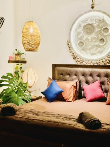 a bedroom with a bed with colorful pillows at The kingdom of ella in Ella