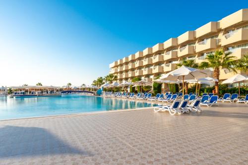 a resort swimming pool with chairs and umbrellas at Seven Seas Jolie Bay - Ultra All Inclusive in Hurghada