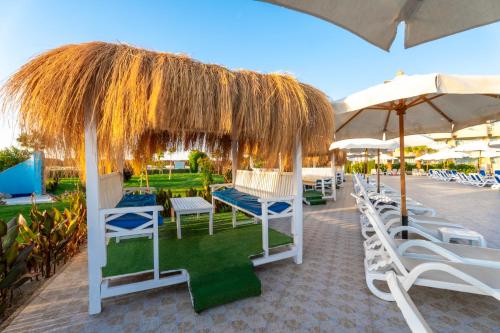 a group of chairs and umbrellas on a patio at Seven Seas Jolie Bay - Ultra All Inclusive in Hurghada