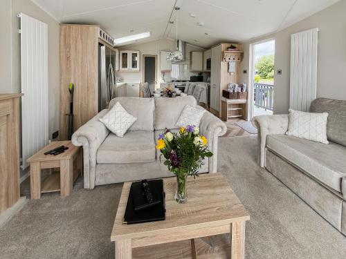 Una sala de estar con un sofá y una mesa con flores. en Reel Paradise - Uk37723, en Ingoldmells