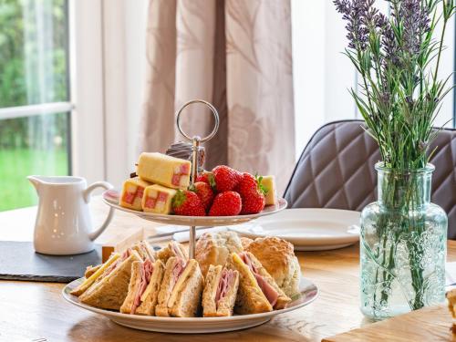 a table with two plates of sandwiches and strawberries at The Gables in Sewerby