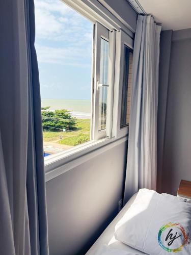 a bedroom with a window with a view of the ocean at Paradise Flat 412 in Nossa Senhora do Livramento