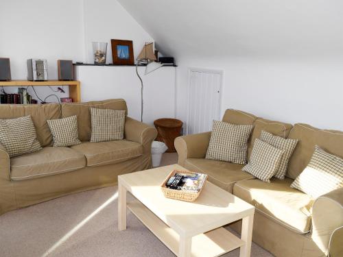 ein Wohnzimmer mit zwei Sofas und einem Couchtisch in der Unterkunft Quays Cottage in Salcombe