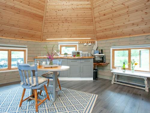 a kitchen with a table and chairs in a cabin at Mallard Roundhouse - Uk33891 in Cullompton
