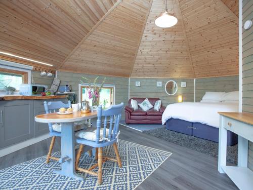 a bedroom with a bed and a table in a room at Mallard Roundhouse - Uk33891 in Cullompton