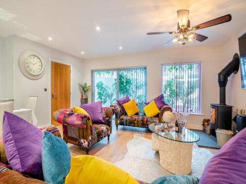 a living room with couches and a ceiling fan at Merriman Lodge in Glastonbury