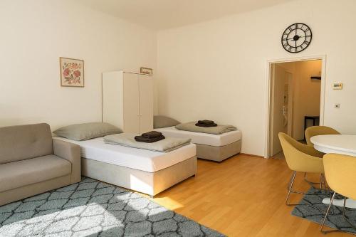 two beds in a room with a couch and a table at Central Apartment in Vienna