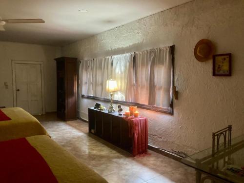 a bedroom with a bed and a table with candles at Rural cotage and sandy bay in Tela