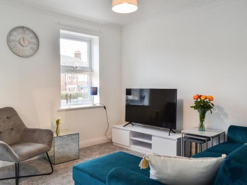 a living room with a blue couch and a tv at Apartment 2 - Uk42623 in Poole