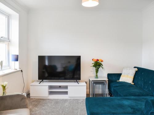 a living room with a blue couch and a tv at Apartment 2 - Uk42623 in Poole