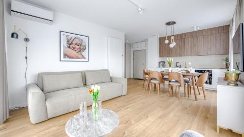 a living room and kitchen with a couch and a table at Sand Dunes, Sun & Snow in Dziwnów