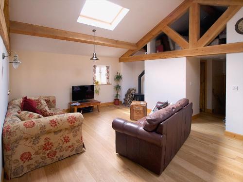 ein Wohnzimmer mit Sofa und Fernseher in der Unterkunft Brimble Cottage in Axminster