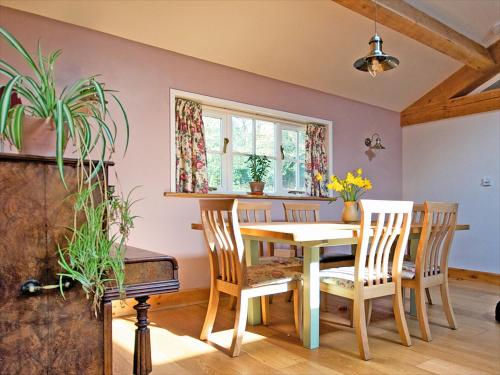 ein Esszimmer mit Tisch und Stühlen in der Unterkunft Brimble Cottage in Axminster
