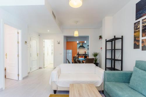 een woonkamer met een witte bank en een tafel bij Apartamentos Molino by Baiti in Ronda