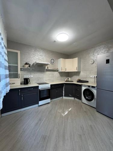 a large kitchen with a white refrigerator and appliances at Yellow House in Pilipets
