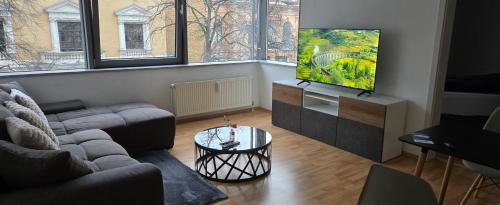 Una sala de estar con un sofá y un televisor de pantalla plana. en Smartes City Apartment - Top Location!, en Halle an der Saale