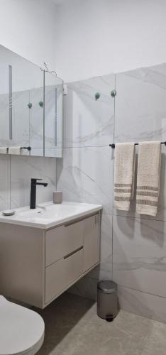 a white bathroom with a sink and a mirror at Sal Casa VILLAGE in Santa Maria