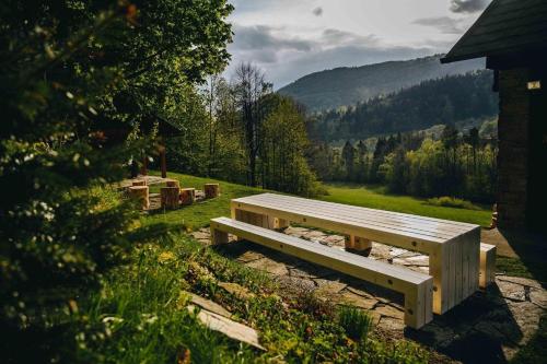 a wooden bench sitting in the middle of a field at Valašská Chaloupka in Rožnov pod Radhoštěm