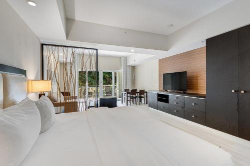 a bedroom with a large white bed and a television at Provident Doral at the Blue Miami in Miami