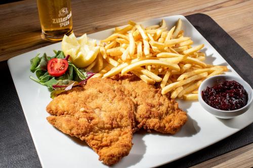 a plate of food with chicken and french fries at Hotel ALPINJUWEL 3-Sterne Superior in Gerlos