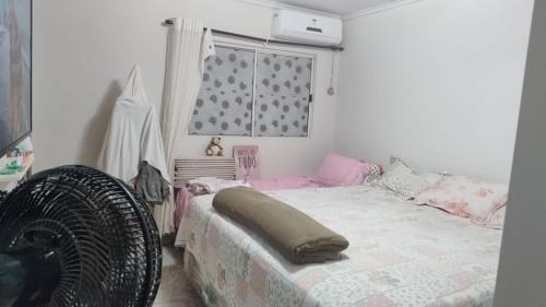 Un dormitorio con una cama y una ventana y un ventilador. en Casa para Temporada, en Ananindeua