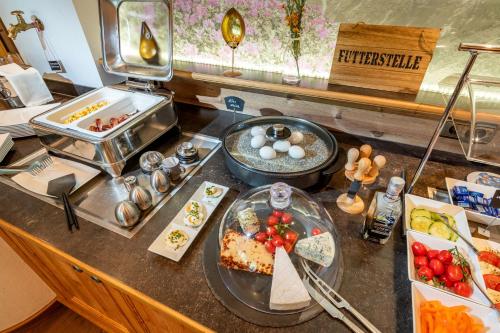 a buffet with food on a counter in a restaurant at Hotel ALPINJUWEL 3-Sterne Superior in Gerlos