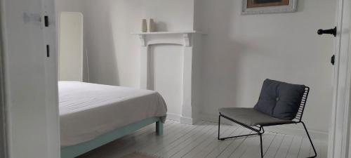 a bedroom with a bed and a chair in it at Kleine Dijk in Diksmuide